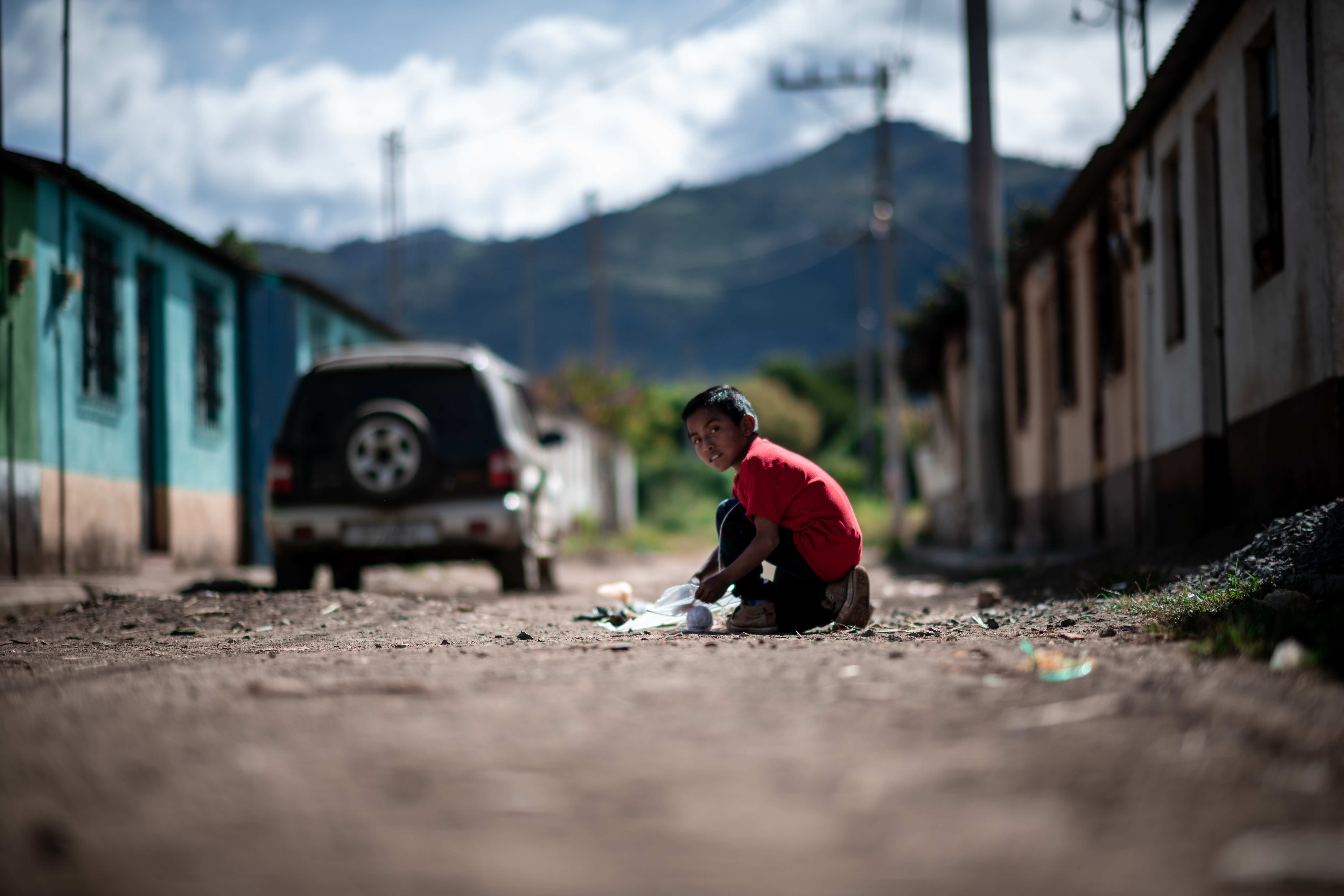 Juan aus Guatemala kniet auf einer Straße (Quelle: Fabian Strauch / FUNKE Foto Services GmbH)