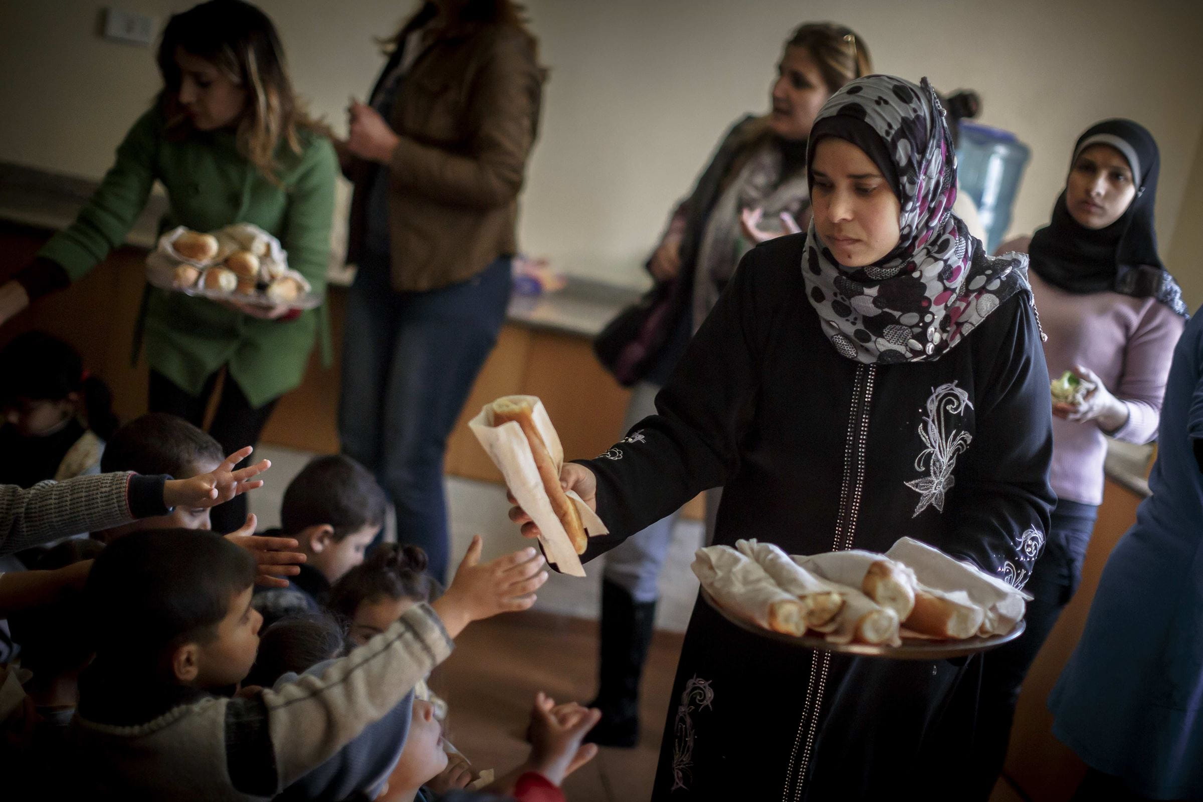 Projektmitarbeiterin reicht Weißbrot an Kinder (Quelle: Jakob Studnar) Projektmitarbeiterin reicht Weißbrot an Kinder (Quelle: Jakob Studnar)