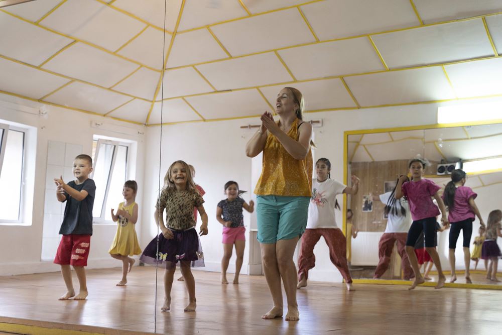 Eine Tanzlehrerin hilft den Kindern, sich bei lauter Musik auf dem ausgebauten Dachboden des Projekts auszutoben (Quelle: Christian Nusch)