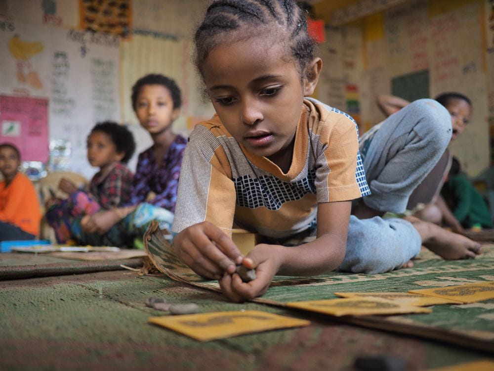 Mädchen Kindergarten Kindergarten Lernen Montessori - Action!Kidz 2019_20 Äthiopien Kindergarten wurde auf Initiative einer SHG Gruppe gegründet Mädchen in Äthiopien spielen auf dem Boden in einem Montessori Kindergarten. (Quelle: Malte Pfau)