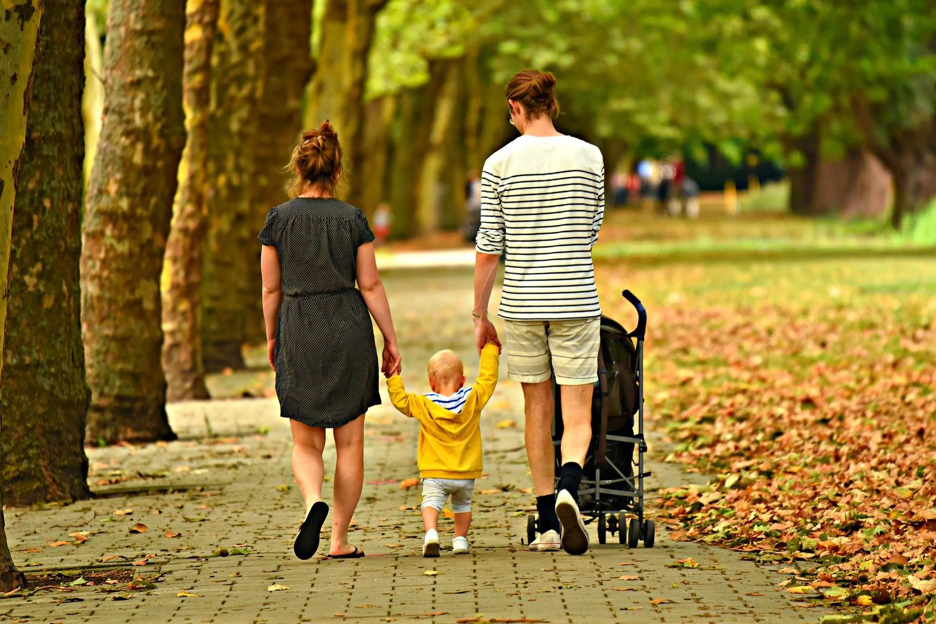 Eltern gehen mit Kind  Hand in Hand spazieren