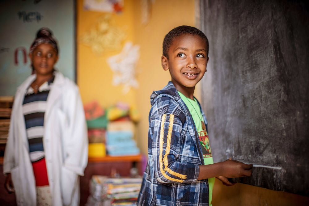KinderNotHilfe in Äthiopien, Junge schreibt an einer Tafel Foto: Jakob Studnar
