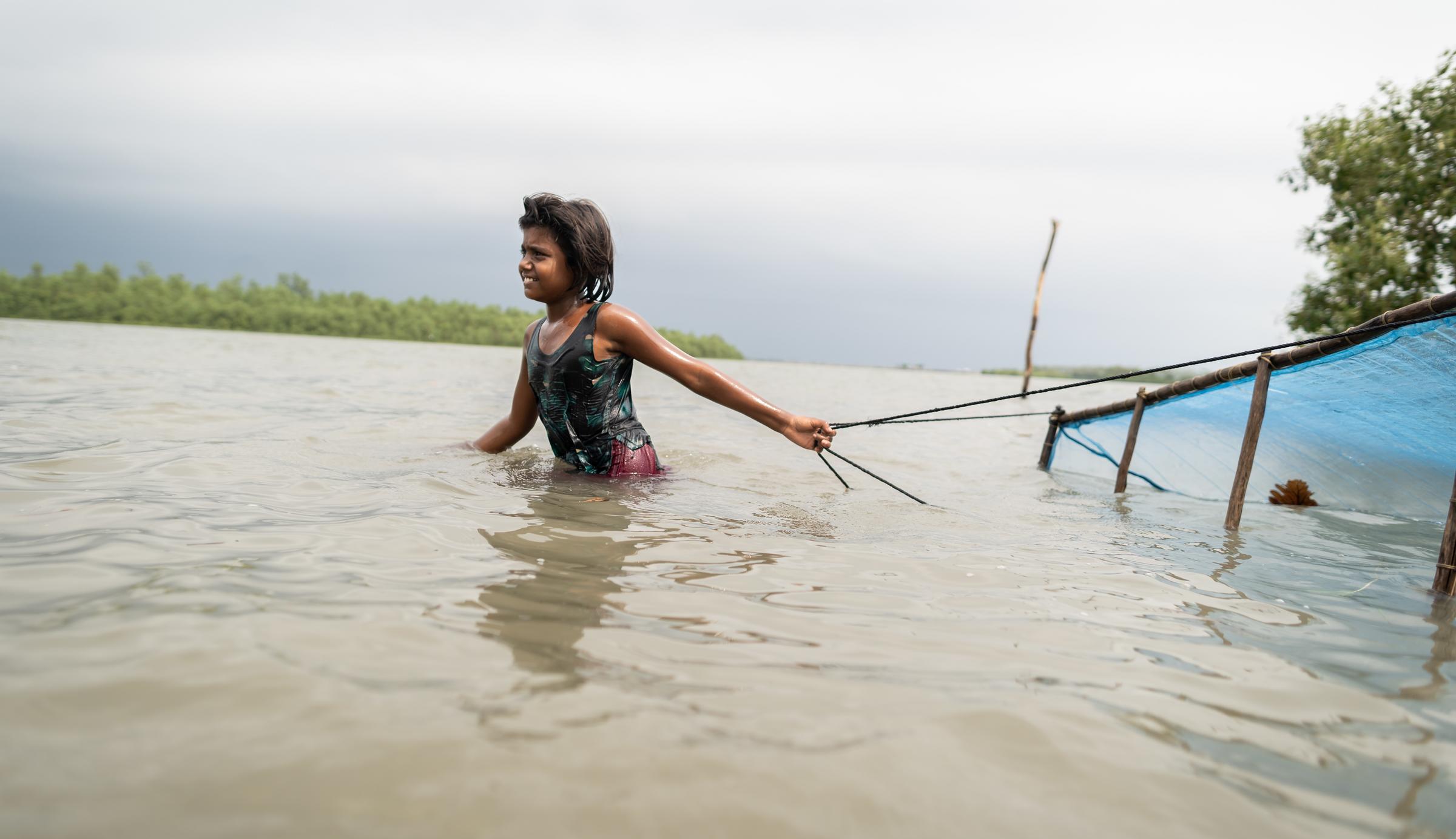 Ein junges Mädchen fischt nach Shrimp in Bangladesch (Quelle: Kindernothilfe)