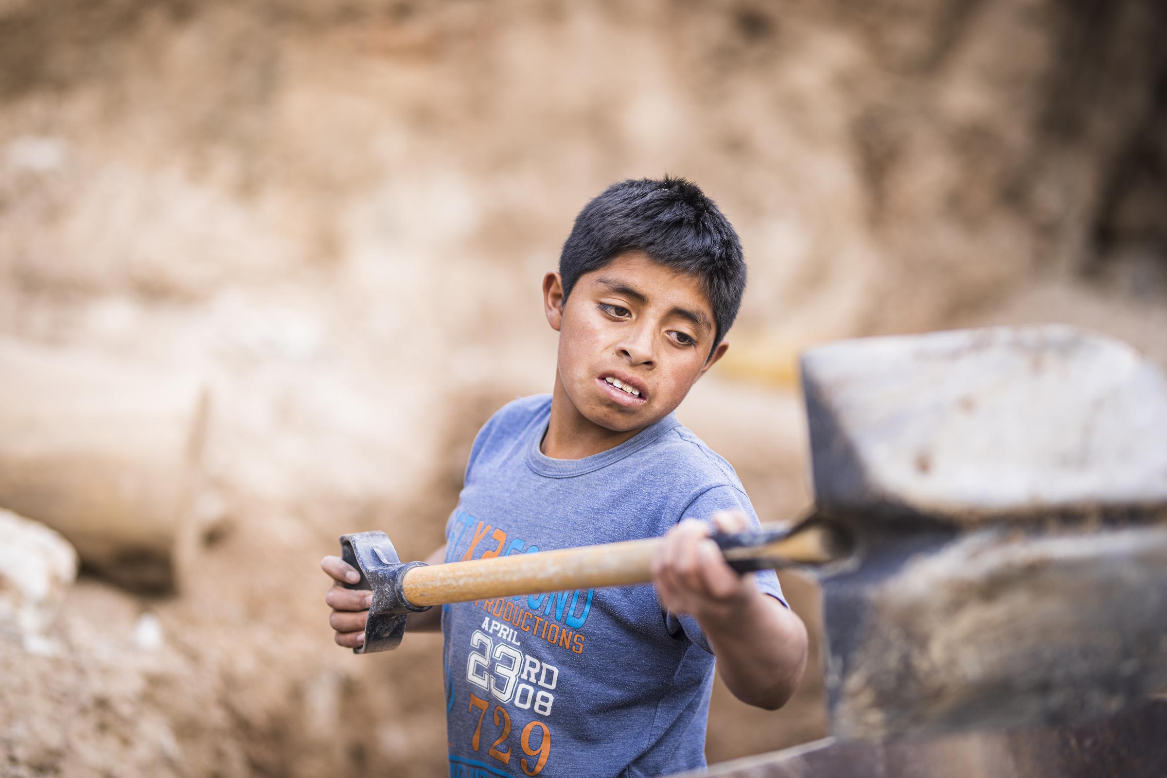 Ein Junge arbeitet schwer in einem Steinbruch in Peru (Quelle: Martin Bondzio/KNH)