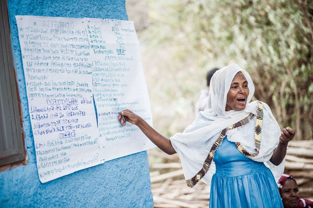 Eine Frau aus Äthiopien steht vor einem Plakat und erklärt ihren Zuhörerinnen etwas. (Quelle: Jakob Studnar)