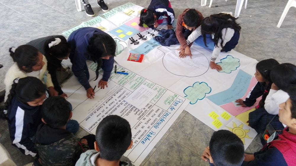 Eine Gruppe Kinder malt auf Plakate ihre Forderungen. (Quelle: Anne Jacob)